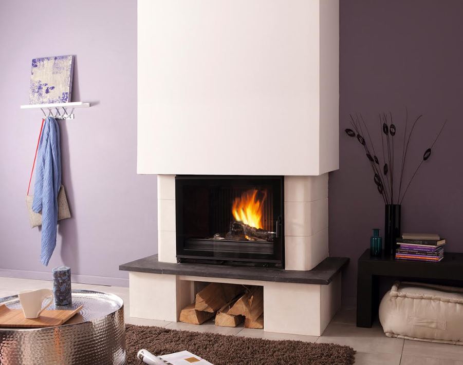 Cheminée contemporaine avec insert encastré, feu vif visible, coffrage blanc et niche à bois en dessous. Parure d’intérieur calme et moderne. installer un insert dans une cheminée ancienne